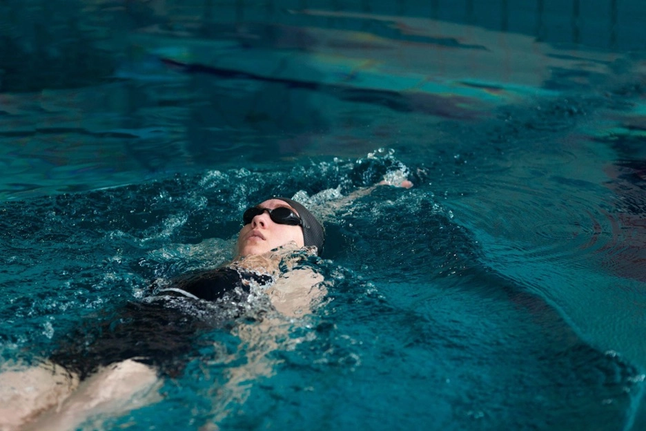 A woman swimming backstroke in a swimming pool
