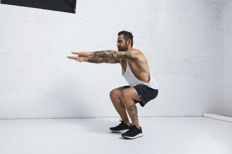 Man performing a bodyweight squat