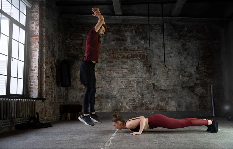Man jumping while woman does a push-up