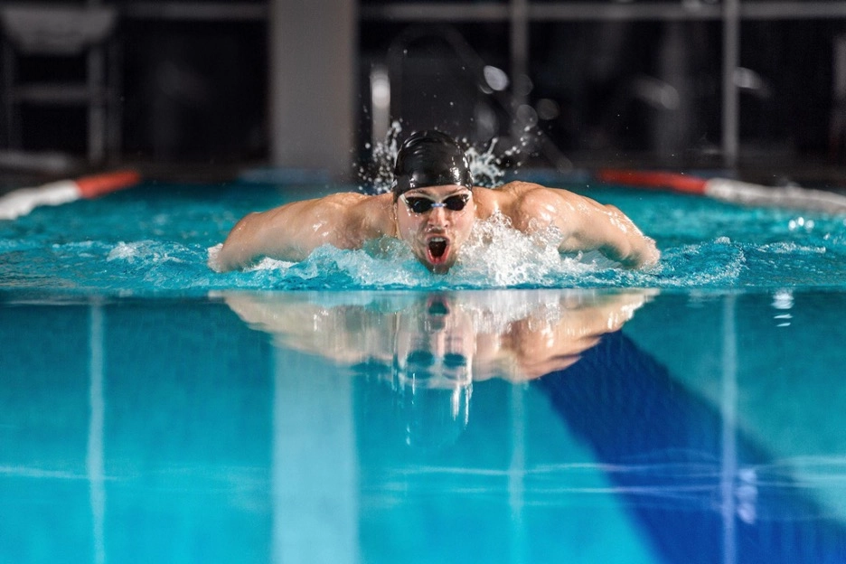 A man doing a butterfly stroke in a swimming pool