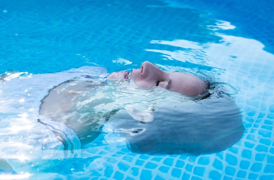 Woman floating on her back in a swimming pool