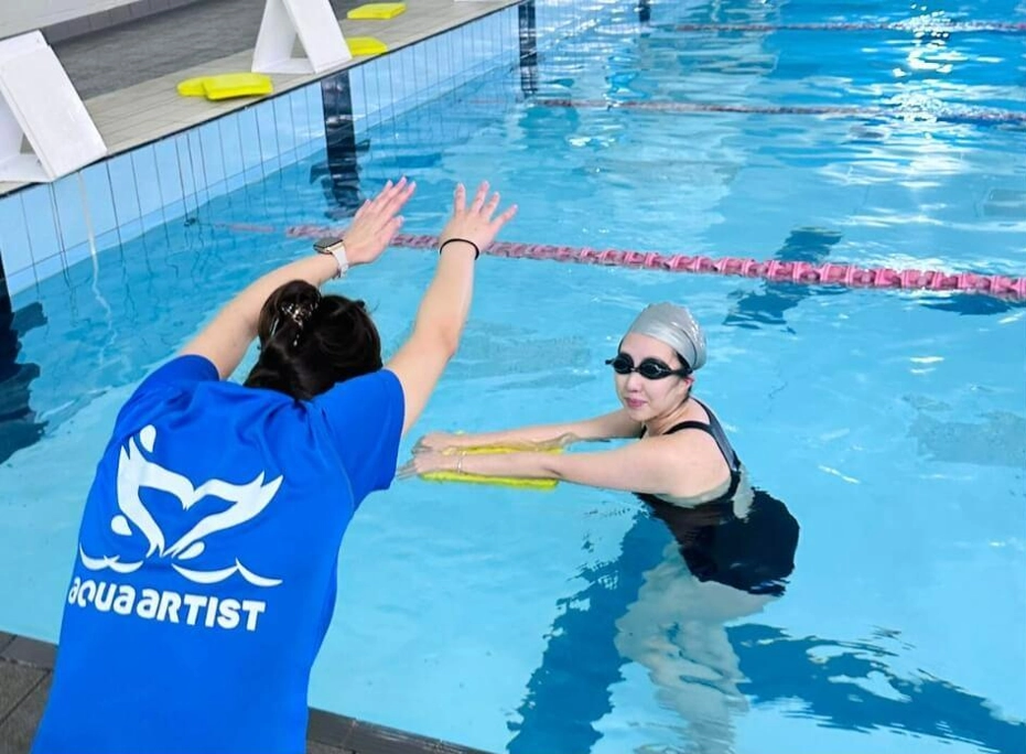 an instructor teaching a student the diving position