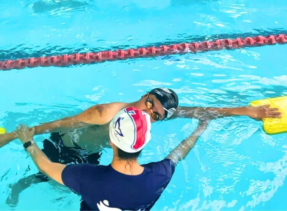 an instructor guiding the student on proper arm swimming position