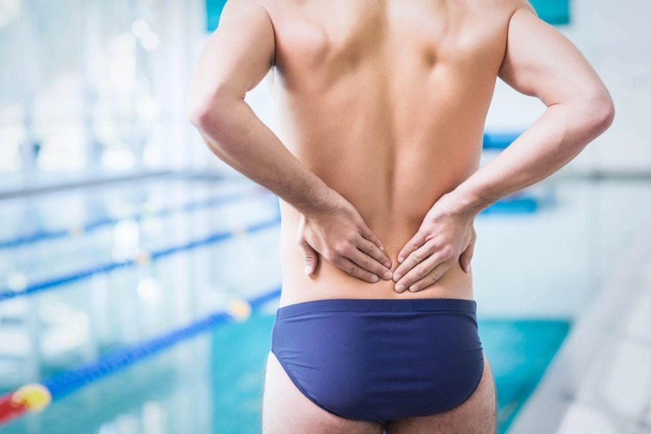 Swimmer with a back ache near a pool