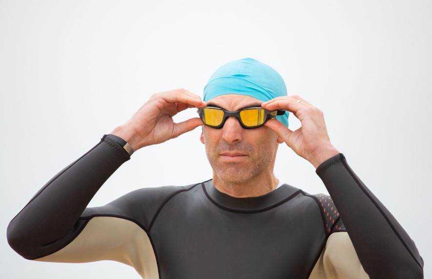 A sportsman in a wetsuit is wearing goggles