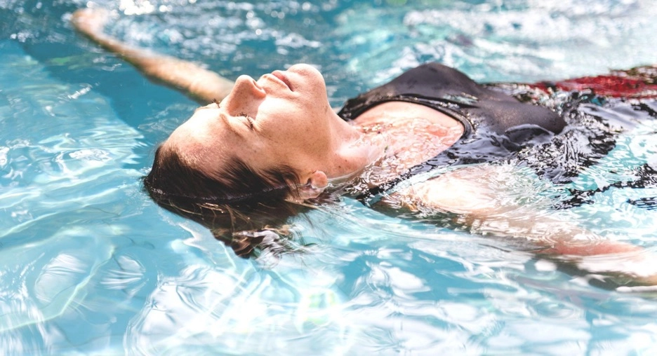 Woman floating on her back in a pool.