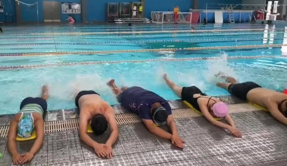 A group of adults practising the diving position